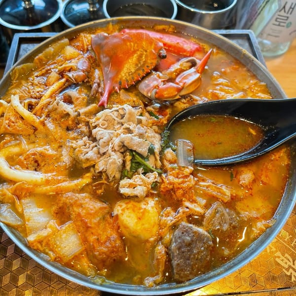 A Tasty Pot! Taiwanese hot pot with crab, sliced meat, and vegetables in a savory broth.