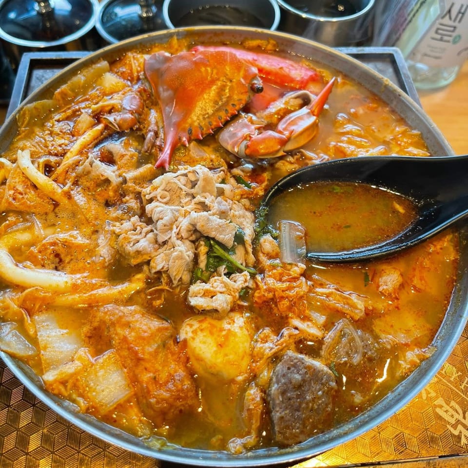 A Tasty Pot! Taiwanese hot pot with crab, sliced meat, and vegetables in a savory broth.
