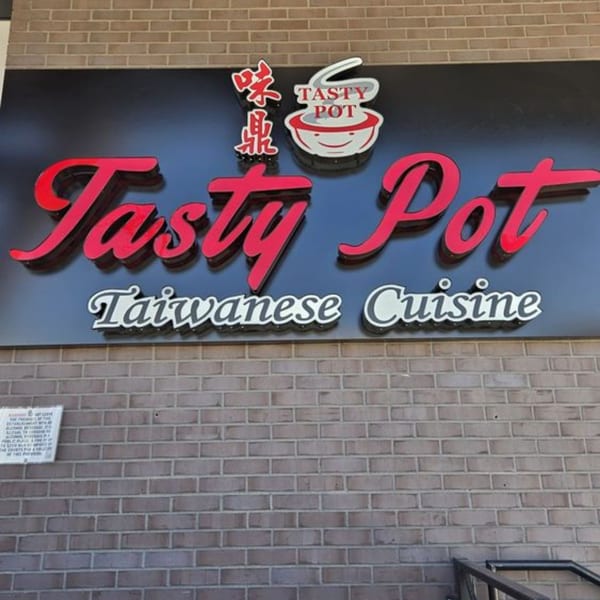 Exterior sign for Tasty Pot Taiwanese Cuisine, featuring red and white lettering on a black background.