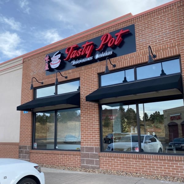 Exterior of Tasty Pot Taiwanese Cuisine restaurant with a red brick facade and black awnings.