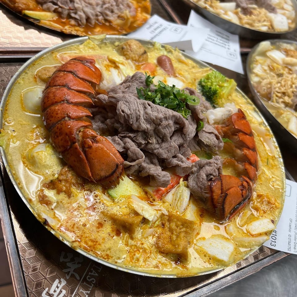 A Tasty Pot! Taiwanese hot pot with lobster, beef, and vegetables in a creamy broth.